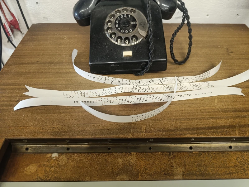 Diese Telefone waren bis zum Ende der DDR im Einsatz. Die Lochstreifen scheinen aus einem Computersystem zu stammen.